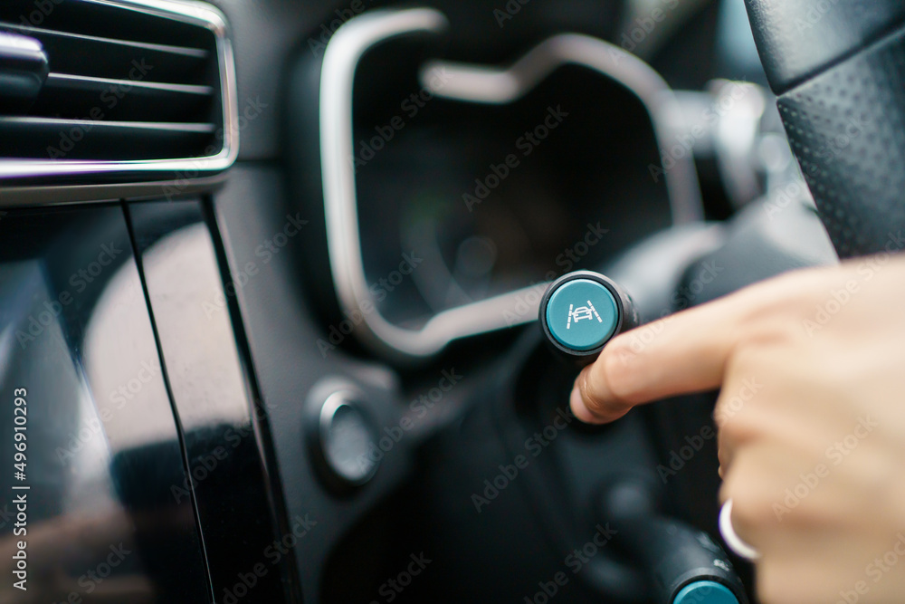Unrecognizable woman driver activating the adaptive cruise control. Unrecognizable woman driver activating the adaptive cruise control.