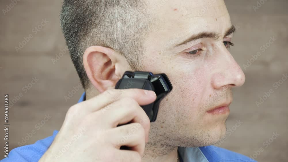 A mature man uses an electric razor. Facial skin care. The beauty of men. Self care authentic. A mature man uses an electric razor. Facial skin care. The beauty of men. Self care authentic.