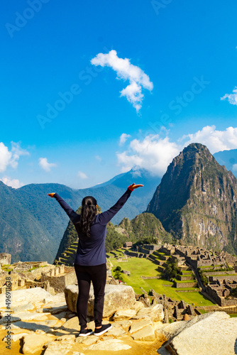Toma vertical de una mujer caucásica mirando la antigua ciudad de Machu Picchu.