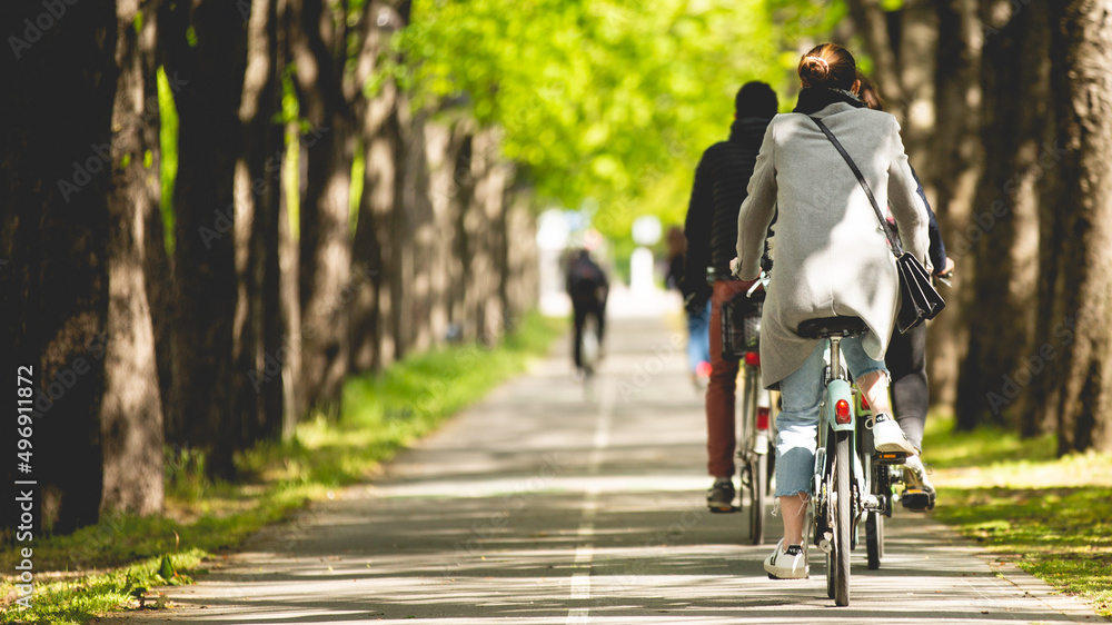 Cycliste sur une piste cyclable et une personne en train de faire du vélo dans Paris. - obrazy, fototapety, plakaty 
