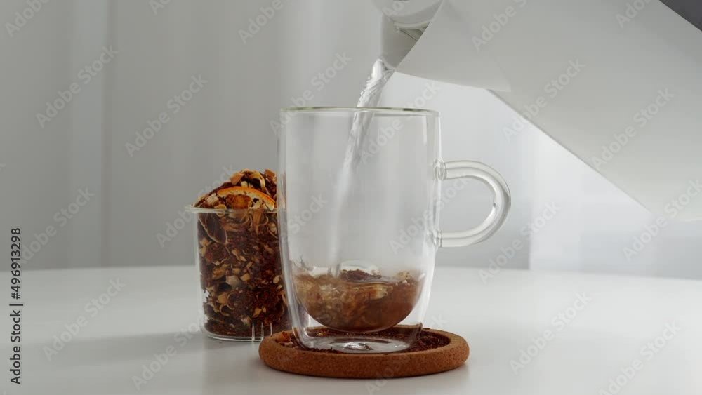 Brew tea leaves with boiling water in a transparent thermos cup Rooibos tea with citrus. A