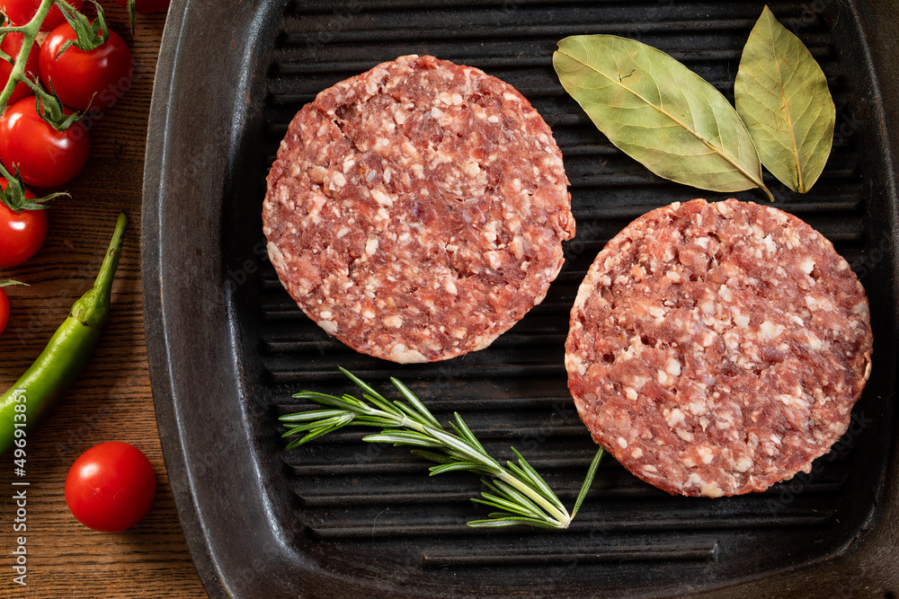Raw Ground beef meat Burger steak cutlets on frying pan on wooden background
Raw Ground beef meat Burger steak cutlets on frying pan on wooden background