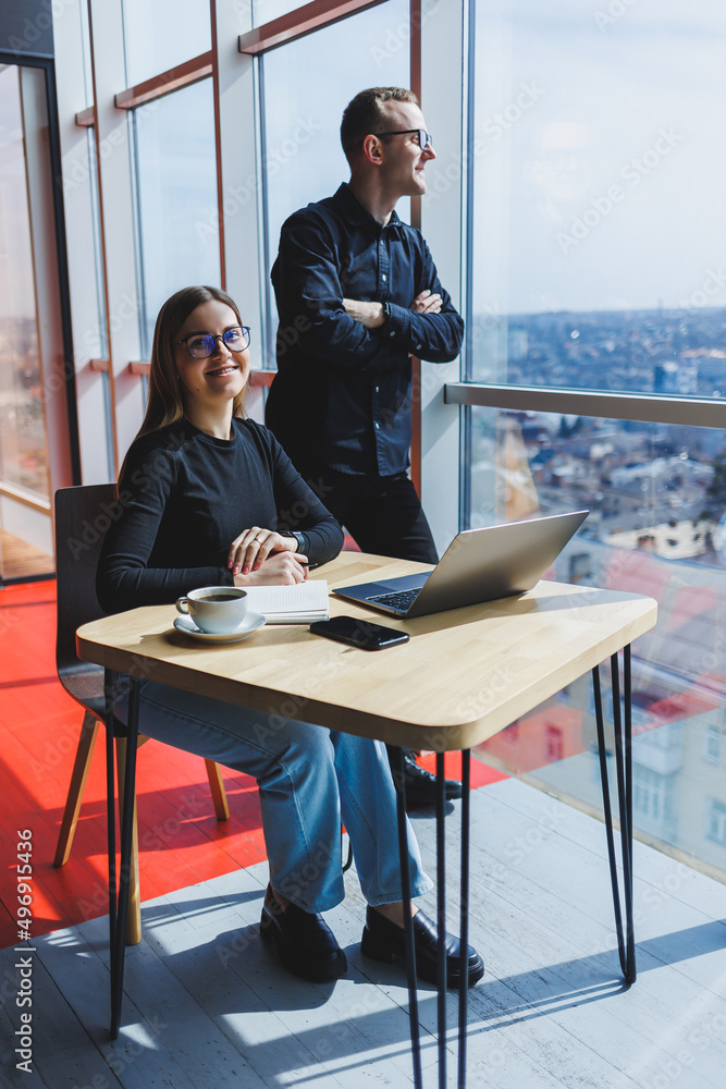 Young business woman behind a laptop wearing glasses sitting at a table having a corporate business meeting with colleagues in a modern office. Business career concept. Free space, selective focus Young business woman behind a laptop wearing glasses sitting at a table having a corporate business meeting with colleagues in a modern office. Business career concept. Free space, selective focus