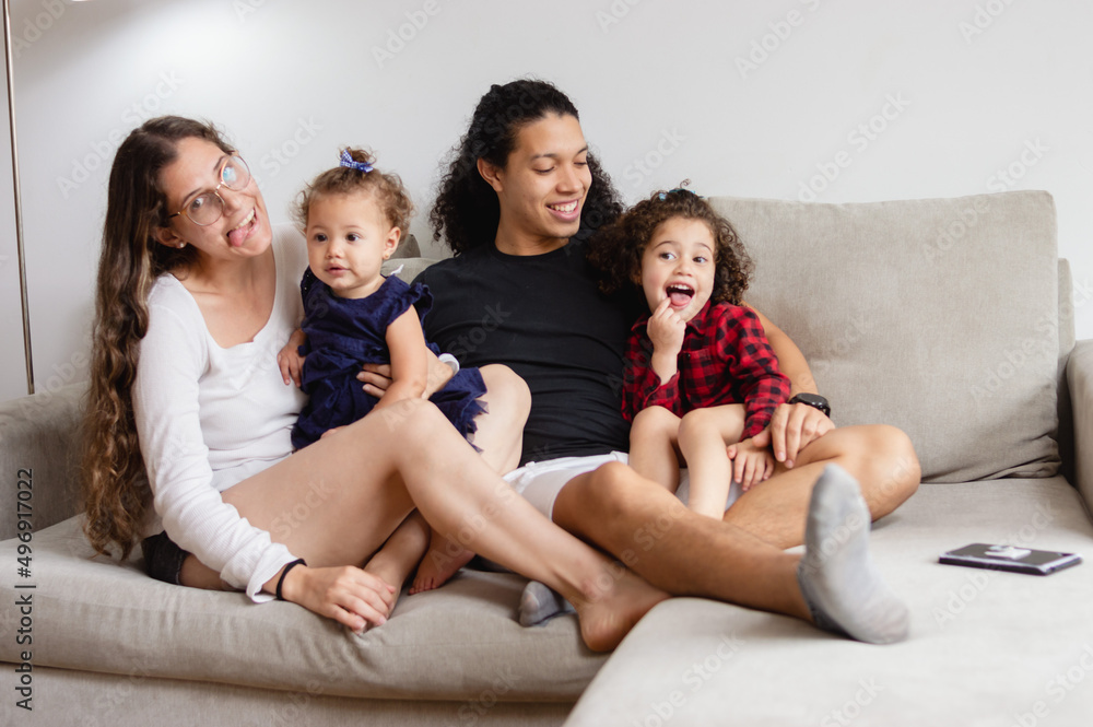 happy family sitting on sofa making funny faces happy family sitting on sofa making funny faces