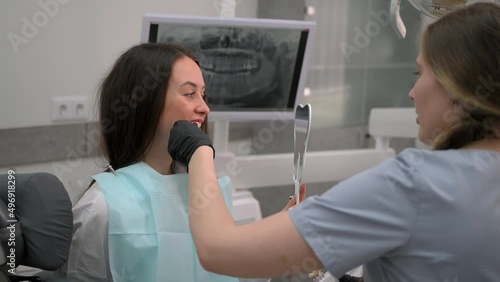 Dentist at work in dental clinic. Matching the shades of the implants using shade guide. Preparation for teeth whitening or implantation in dental office.