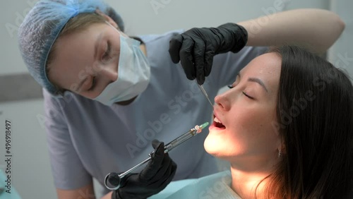 Close up of a female dentist giving her patient an anesthesia injection in dental clinic