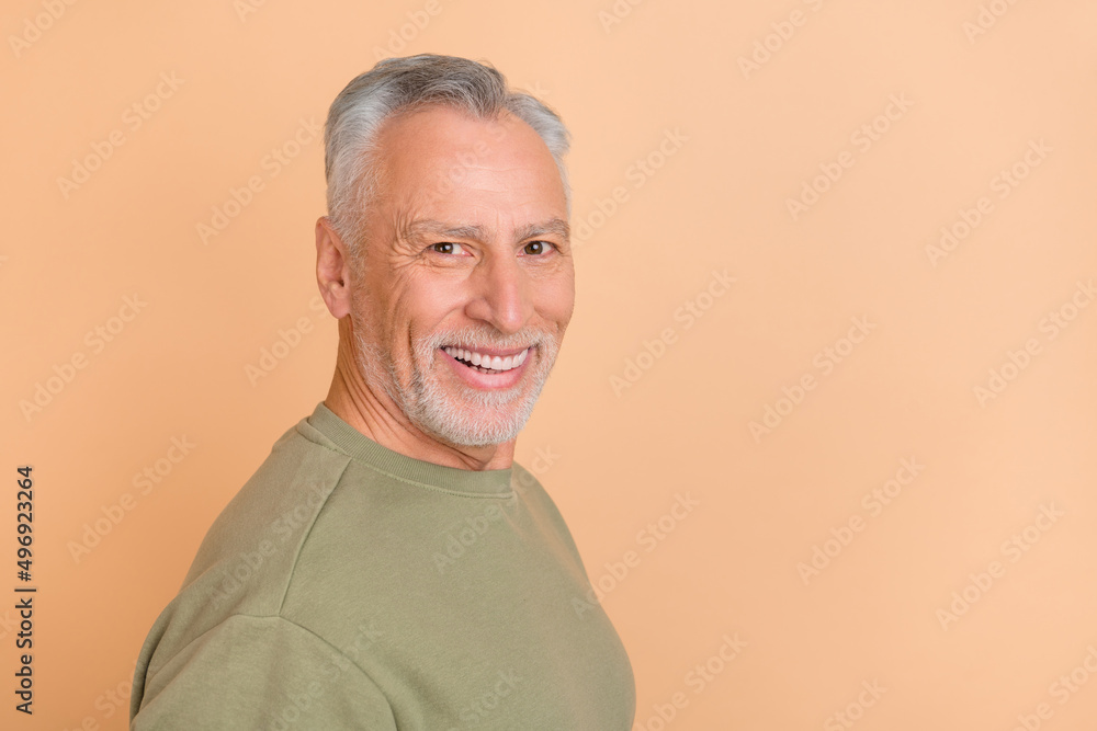 Profile side photo of cheerful mature man smart agent promoter wear casual clothes isolated over beige color background Profile side photo of cheerful mature man smart agent promoter wear casual clothes isolated over beige color background