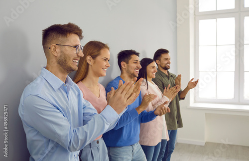 Happy diverse businesspeople applaud thank presenter for meeting or speech. Smiling employees or young people clap hands show acknowledgement and respect. Team greeting or congratulating. photo