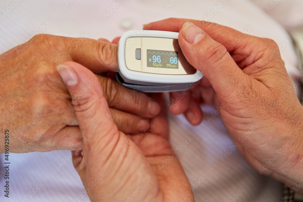 Hände von Arzt halten Hand von Patient mit Pulsoximeter Hände von Arzt halten Hand von Patient mit Pulsoximeter