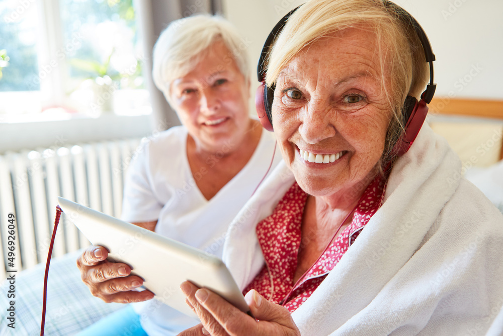 Glückliche Seniorin mit Kopfhörer und Tablet beim Videochat Glückliche Seniorin mit Kopfhörer und Tablet beim Videochat
