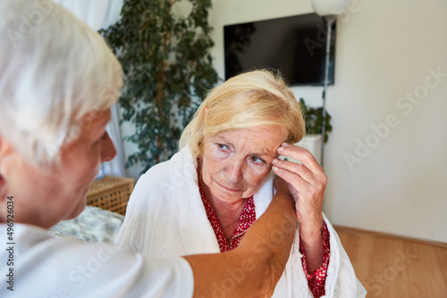 Frau vom Pflegedienst betreut depressive Seniorin mit Demenz