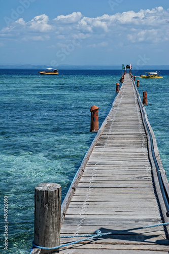 Island dock on a turquoise tropical sea with boats in the background Cebu Philippines 20070401.