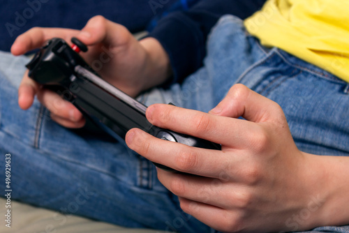 Teenager playing on his phone with console. 