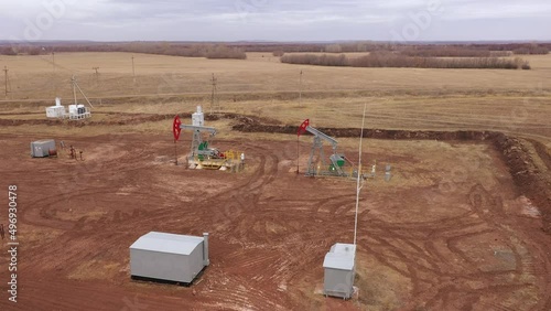 Pump jack in vast oil fields in Russia. Pipelines transporting oil from oil pumps, aerial drone shot