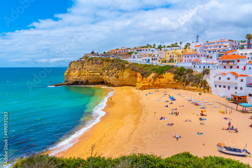 People are sunbathing on Praia de Carvoeiro beach in Portugal