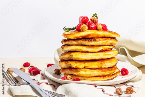 Classic homemade American pancakes with frozen raspberries, hazelnut and mint. Healthy breakfast