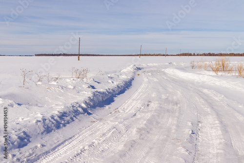 a cleared winter road through a field