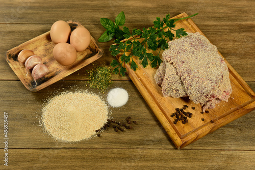 Veal milanese presented on the table with ingredients