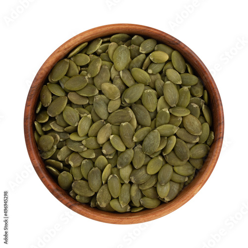 bowl of green pumpkin seeds on white background, top view