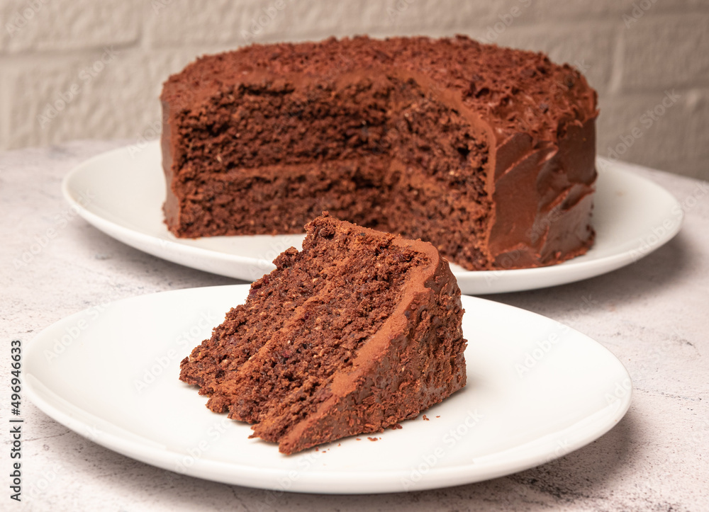 Date, chocolate and sweet potato cake with cut slice on seperate plate Date, chocolate and sweet potato cake with cut slice on seperate plate