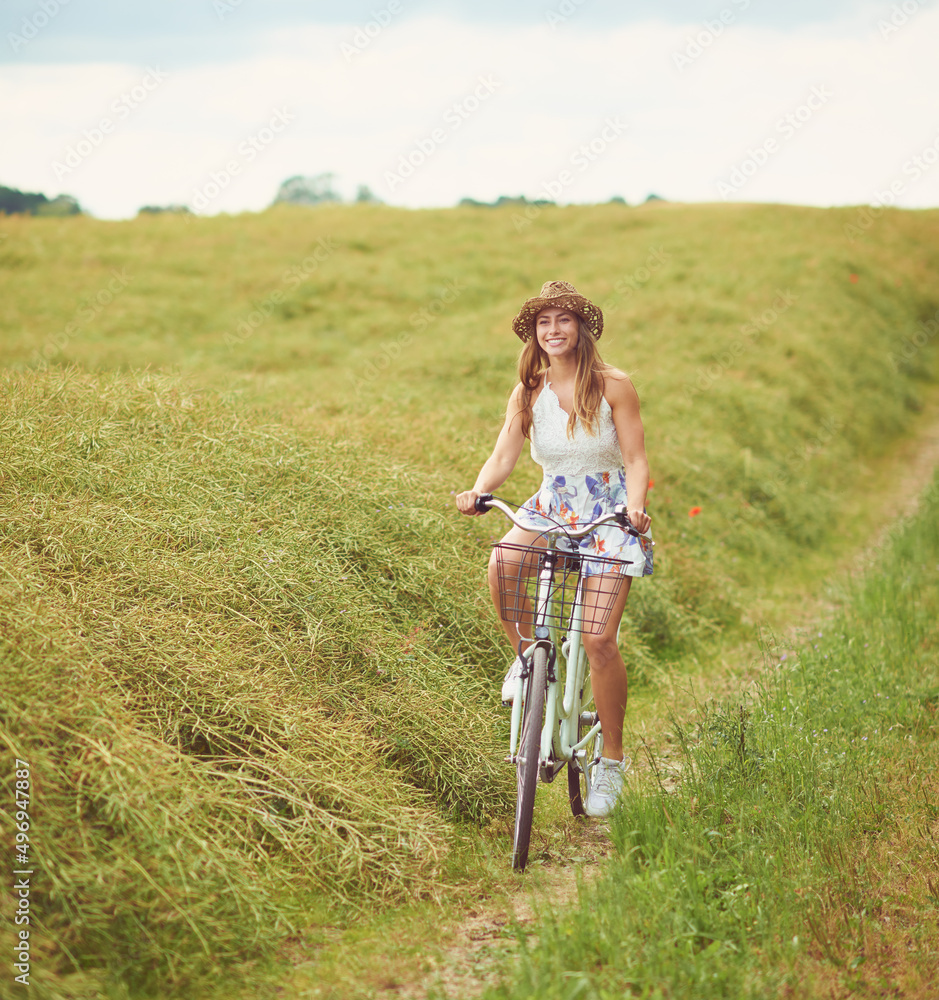 The city is exciting, but the country is beautiful. Shot of a young woman cycling through the countryside. The city is exciting, but the country is beautiful. Shot of a young woman cycling through the countryside.