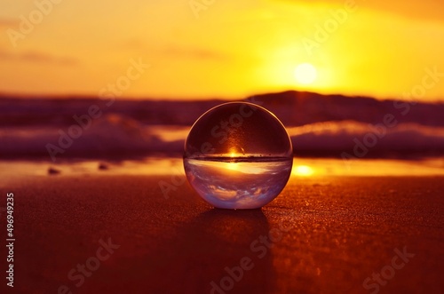 Bola de cristal reflejando amanecer el la playa © Maelia Rouch
