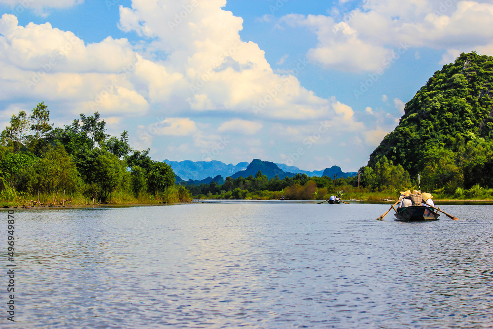 Fototapeta premium Tourists Enjoy the Boat Ride through the Limestone Mountains the Perfume Pagoda outside of Hanoi, Vietnam