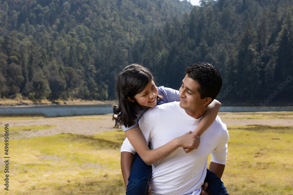 Mexican father and daughter playing outdoors Mexican father and daughter playing outdoors