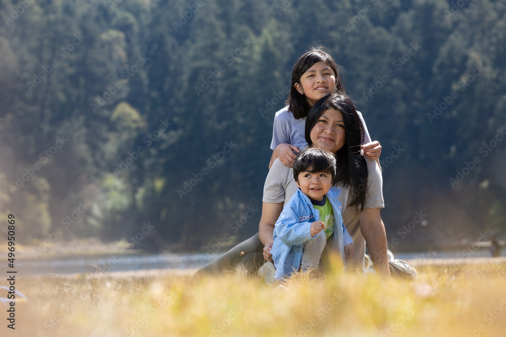 Mexican mother with daughter and son hugging outdoors Mexican mother with daughter and son hugging outdoors