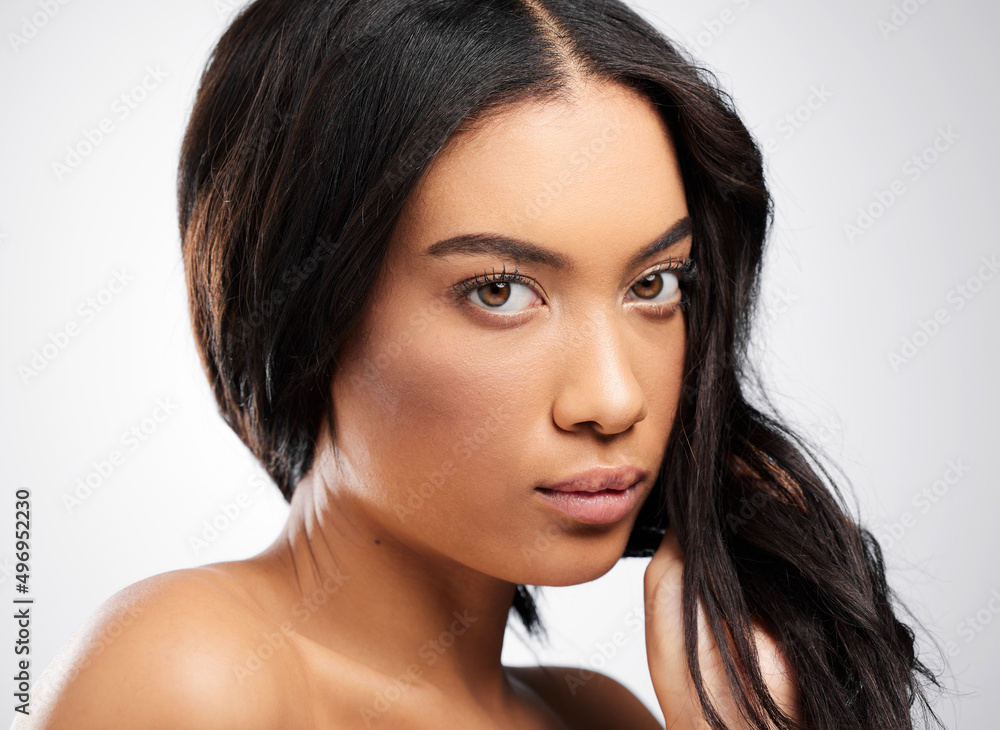 Fototapeta premium Youve gotta take your haircare seriously. Cropped portrait of an attractive young woman posing in studio against a grey background.