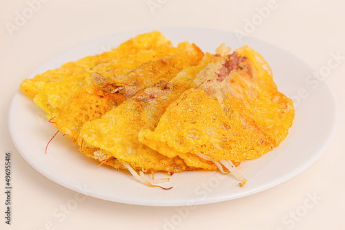 Banh xeo, Vietnamese Crêpes or Pancakes with pork, shrimp, onions, beasn sprouts inside, Vietnamese food isolated on white background. close-up