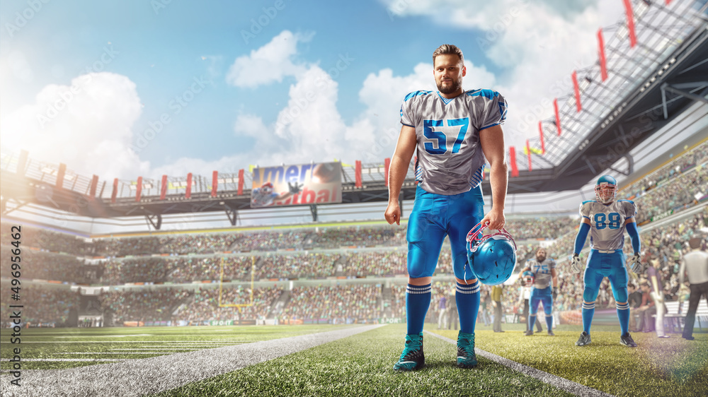 American football. Football player stands in stadium and holds a helmet in his hand. Sport. Stadium during the day