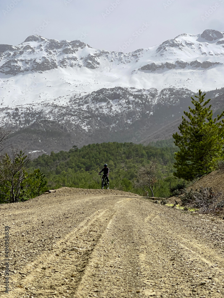 adventurer riding a bike with a view of snowy mountains
