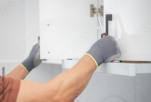 Cabinetmaker Finishing Installation of a New Kitchen Cabinets