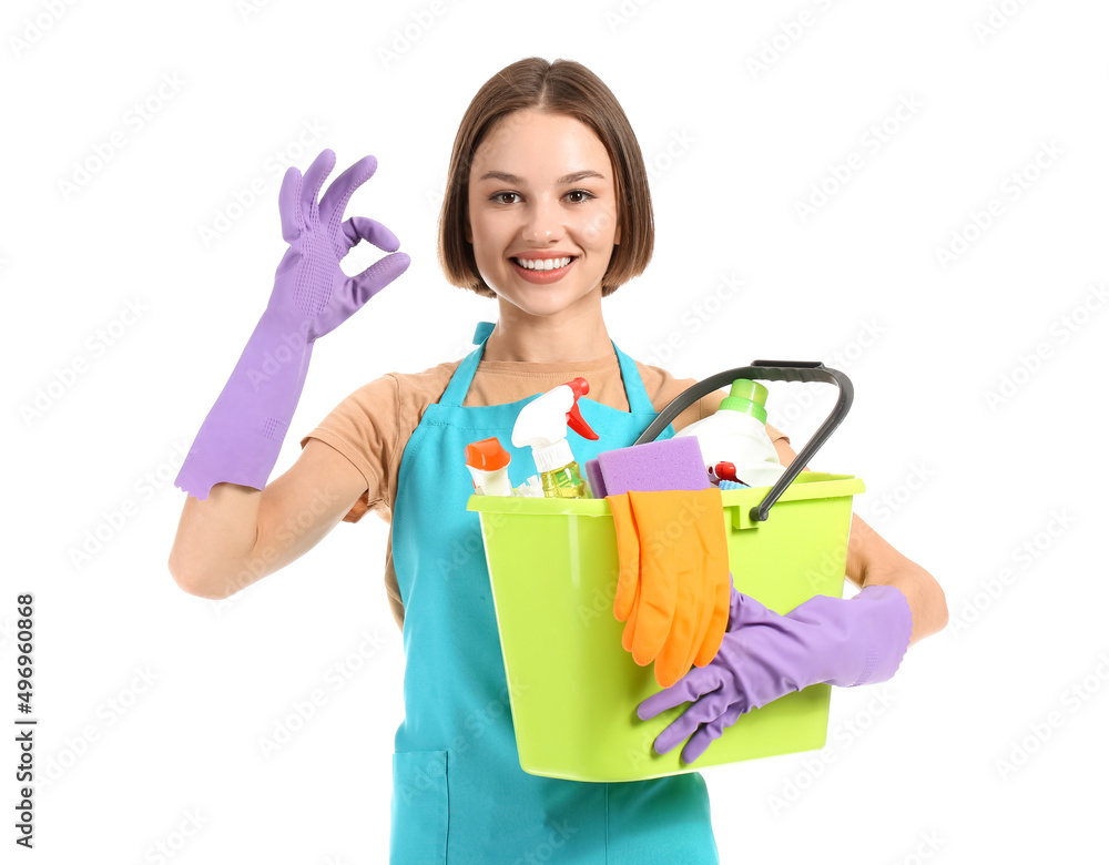 Beautiful young woman with cleaning supplies showing OK on white background Beautiful young woman with cleaning supplies showing OK on white background