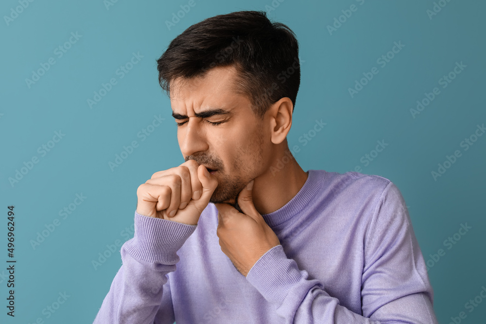 Ill young man with sore throat on blue background Ill young man with sore throat on blue background