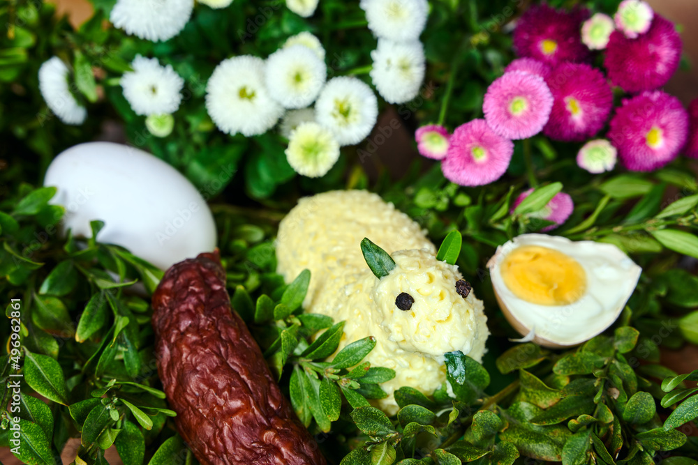 Traditional Easter lamb made of butter, boxwood twigs and colorful spring flowers Traditional Easter lamb made of butter, boxwood twigs and colorful spring flowers
