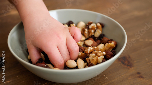 Hands of a kid taking helthy snacks from a bowlPeople taking healthy snacks from a bowl