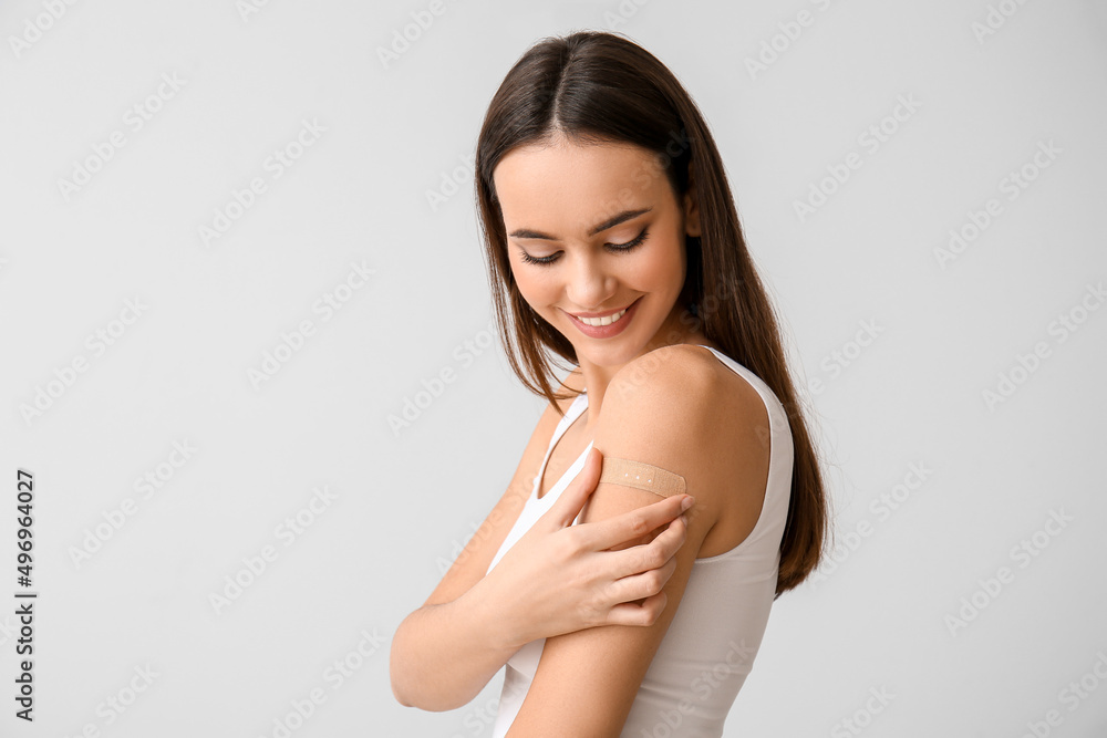 Φωτογραφία Young woman with applied medical patch on light background
