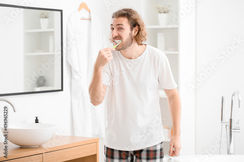 Handsome young man brushing...