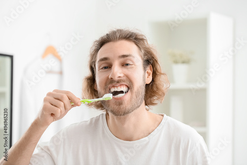 Handsome young man brushing...
