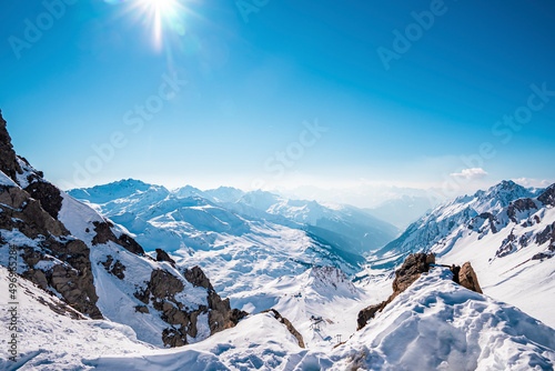 Shining sun over snow covered mountain. Beautiful white landscape against blue sky. Alps on sunny day during winter.
