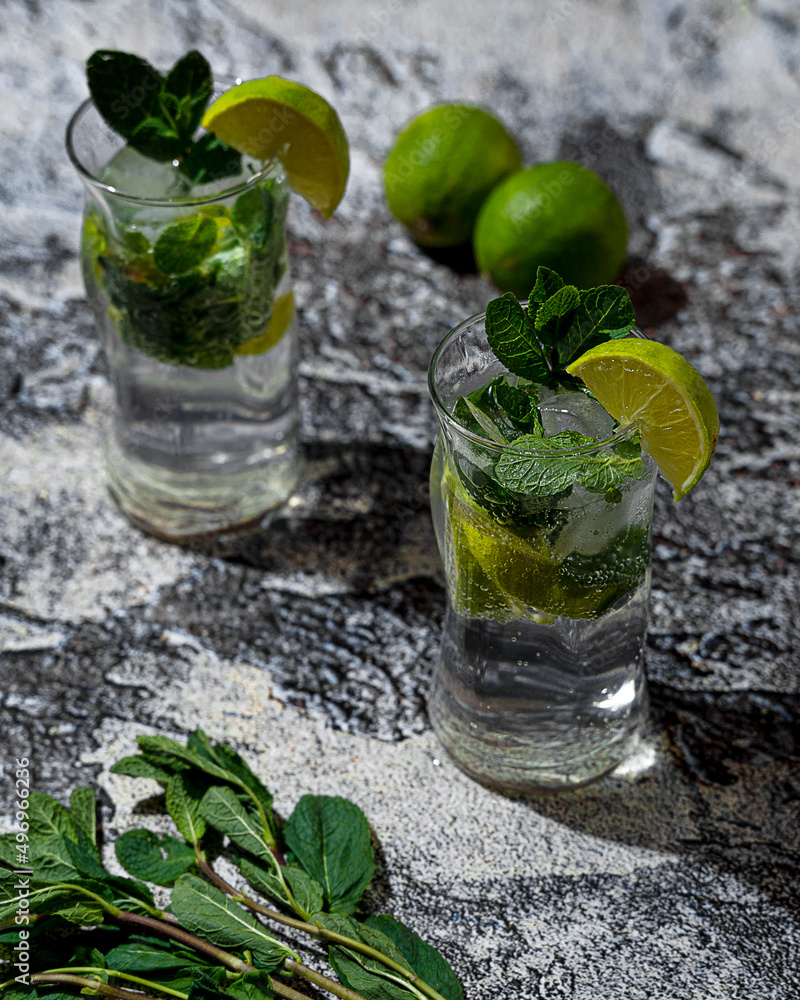 Mojito cocktails with lime and mint in a pasabahce amorf glass on a gray marble background Mojito cocktails with lime and mint in a pasabahce amorf glass on a gray marble background