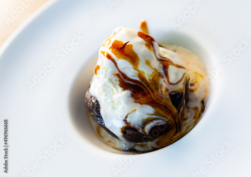 Delicious brownie with soft ice cream and caramel icing. Popular chocolate dessert