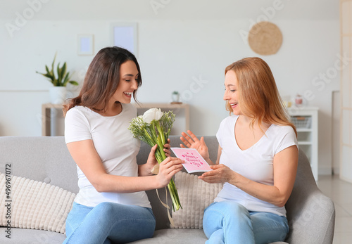 Young woman greeting her mother for International Women's Day at home