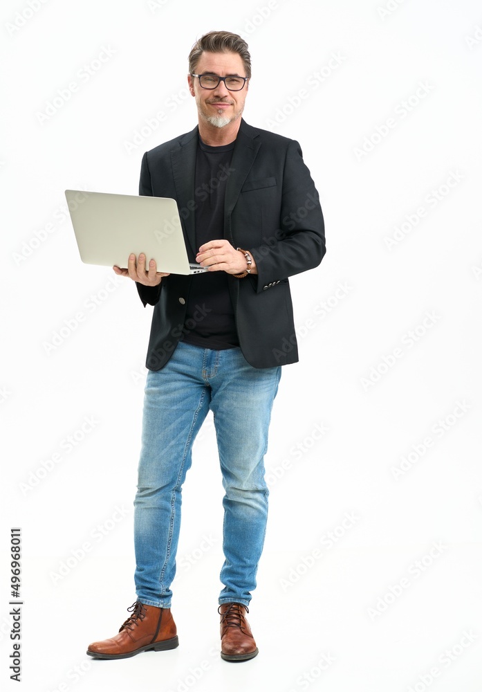 Middle age businessman in business casual using laptop computer. Entrepreneur in jeans and jacket. Mid adult, mature age man, happy smiling. Full length portrait isolated on white. - obrazy, fototapety, plakaty 