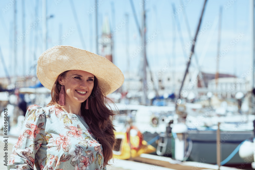 smiling modern tourist woman in floral dress on pier
