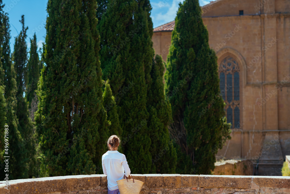 Fototapeta premium Seen from behind traveller woman sightseeing in Tuscany, Italy
