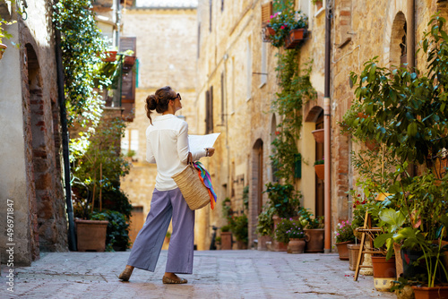 stylish woman with map enjoying promenade in Tuscany, Italy photo
