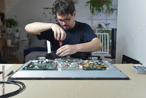 The man repairing broken tv at home